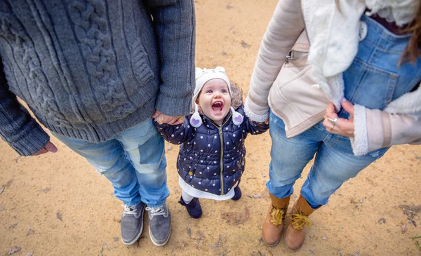 Mann und Frau halten glückliche Hände, kleines Mädchen — Stockfoto