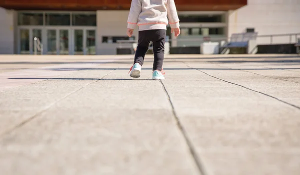 Little girl with sneakers and leggins training outdoors — Stock Photo, Image