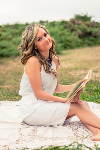 Ρομαντικό κορίτσι διαβάζοντας ένα βιβλίο καθισμένος σε εξωτερικούς χώρους — Φωτογραφία Αρχείου