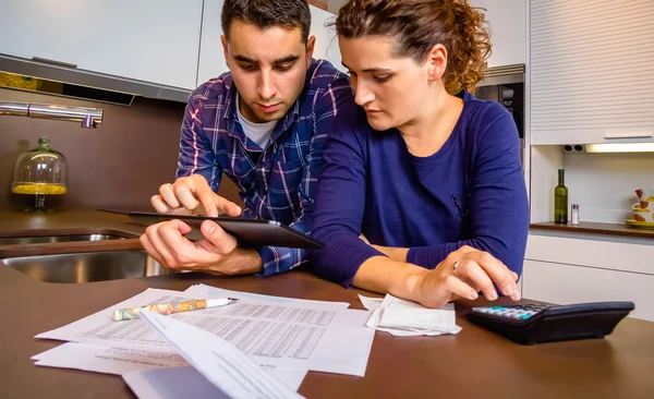 Casal revisando suas contas com um tablet digital — Fotografia de Stock