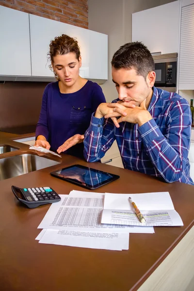 Jeune couple sans emploi avec dettes révisant leurs factures — Photo