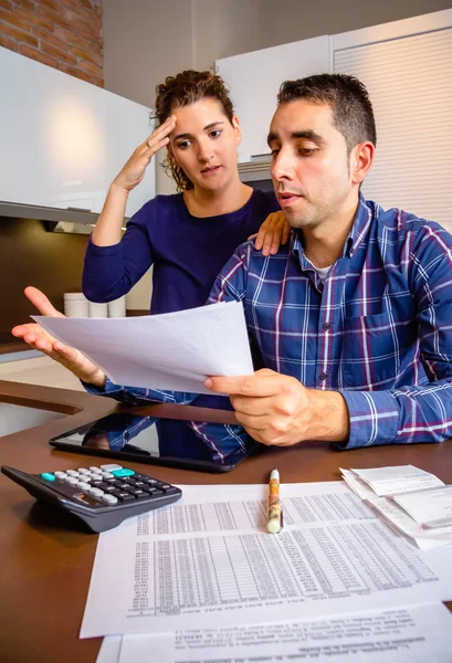 Arbeitsloses junges Paar mit Schulden bei der Überprüfung ihrer Bankkonten — Stockfoto