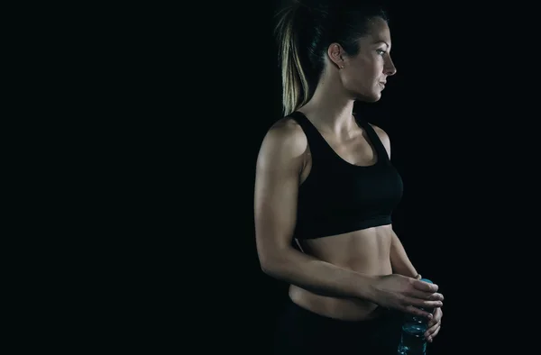 어두운 배경 위에 검은 상단 체육 금발 여자 — 스톡 사진