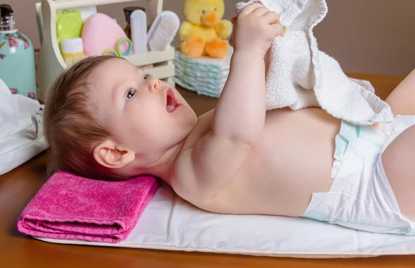 Baby liggend spelen met een kleine handdoek — Stockfoto