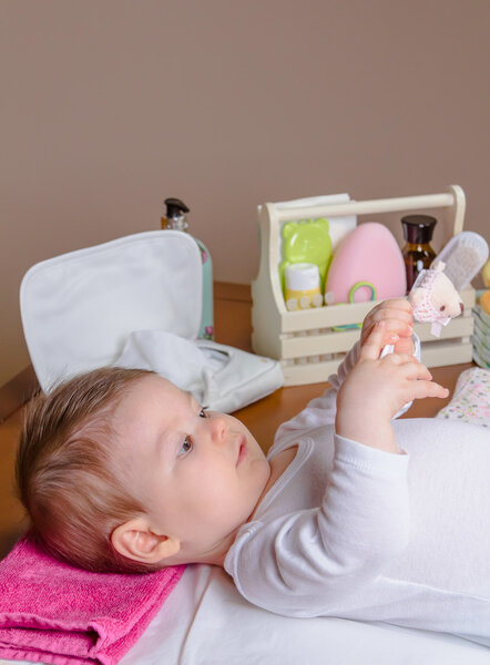 Baby lying playing with a children comb