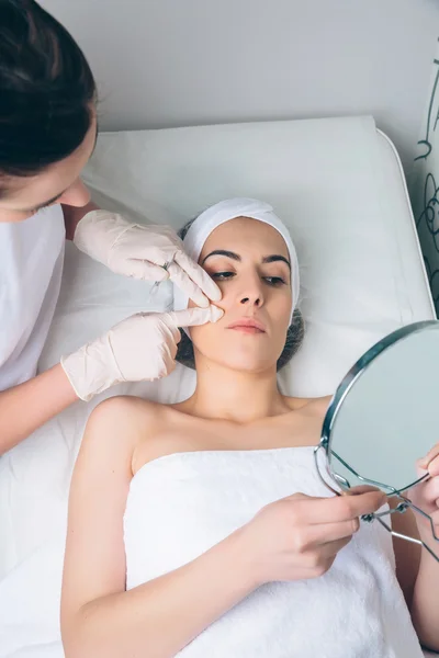 Female doctor showing to patient the face zones for a treatment — Stock Photo, Image