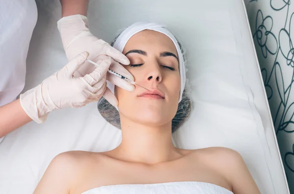 Woman getting cosmetic injection in her face on clinical center — Stock Photo, Image