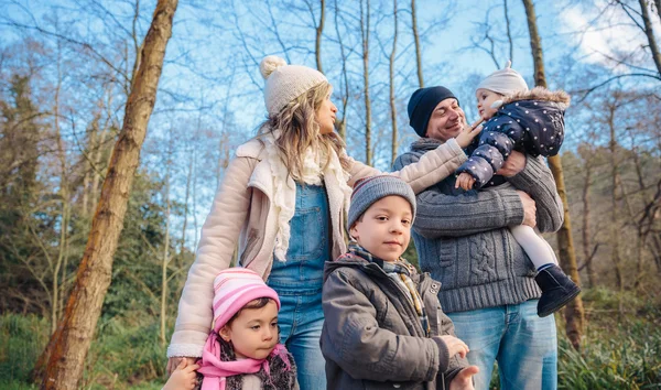 Família feliz desfrutando juntos lazer na floresta — Fotografia de Stock