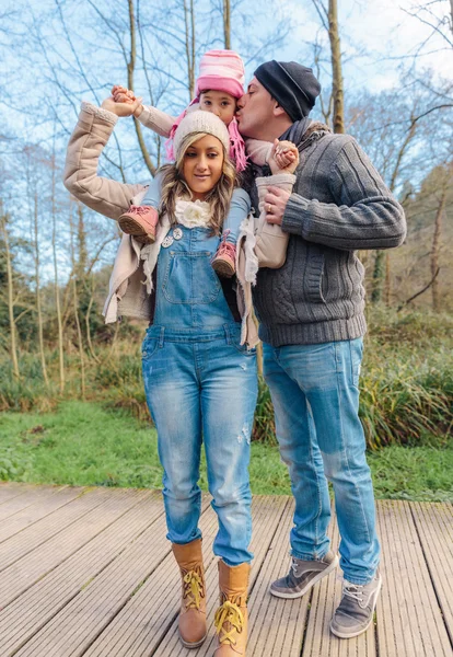 Padre besando a su pequeña hija sobre un fondo del bosque . —  Fotos de Stock