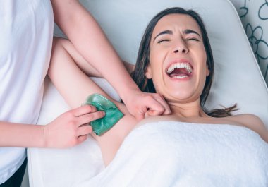 Genç kadın Depilasyon koltukaltı ağrısı tarafından bağırarak