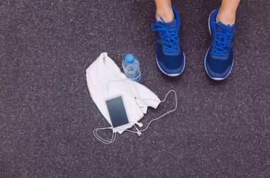 Adam ayaklı spor ayakkabı, havlu, su ve spor salonu kat smartphone
