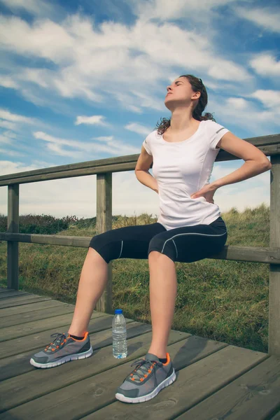 Atletische vrouw haar rugspieren raken door letsel — Stockfoto
