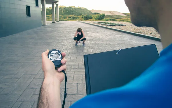 Trainer hand using chronometer to timing woman training — Stock Photo, Image