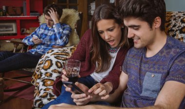 Genç çift kanepede oturan smartphone