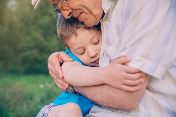 Heureux petit-fils câlin à son grand-père à l'extérieur — Photo