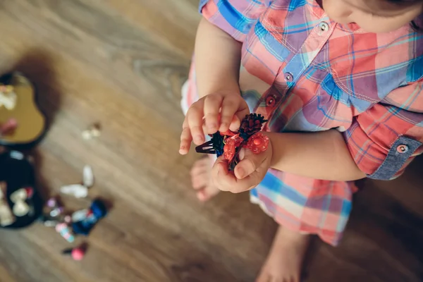 Девочка играет с заколками в руках — стоковое фото