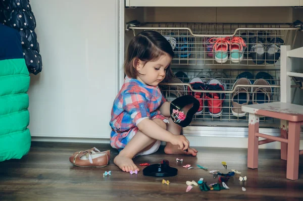 Dziecko dziewczynka gra z spinki do włosów siedzi w podłodze — Zdjęcie stockowe