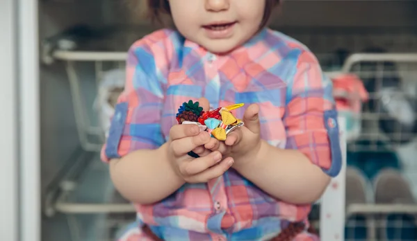 Menina bebê brincando com grampos de cabelo nas mãos — Fotografia de Stock