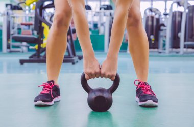 Kadın crossfit eğitimde kettlebell kaldırmaya hazır