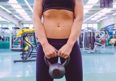 İnce bel ve kettlebell tutarak siyah spor giyim kadın ile