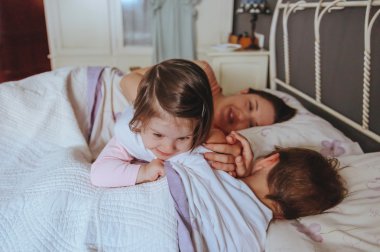 Küçük kız yatakta yatan çocuk üzerinde oynama