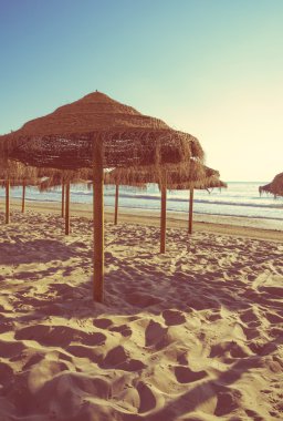 Gün batımında boş Beach ahşap şemsiye