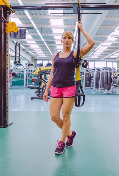 Woman standing out with a fitness straps — Stock Photo, Image