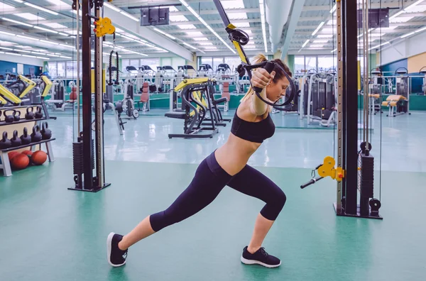 Mujer haciendo entrenamiento de suspensión con correas de fitness — Foto de Stock