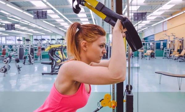 Vrouw die suspensietraining doet met fitnessbandjes — Stockfoto