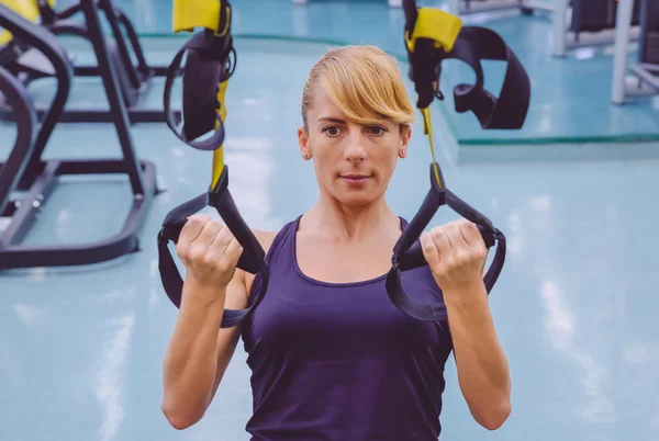 Vrouw die suspensietraining doet met fitnessbandjes — Stockfoto