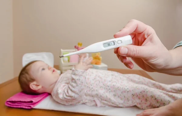 Die Hand der Mutter misst die Temperatur des Babys im Thermometer — Stockfoto