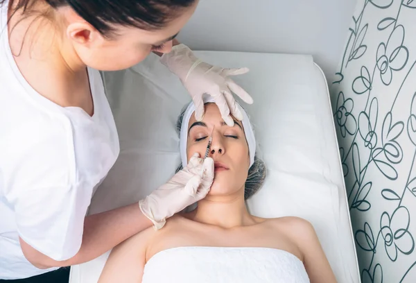 Woman getting cosmetic injection in her face on clinical center — Stock Photo, Image