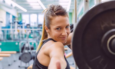 Kadın gülümsüyor ve eğitimden sonra istirahat baş parmakları