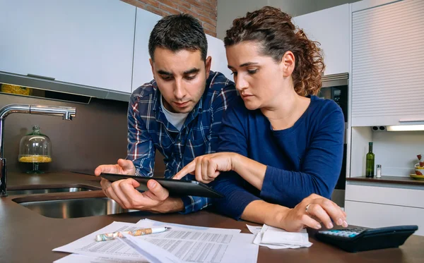 Pareja revisando sus cuentas con una tableta digital — Foto de Stock