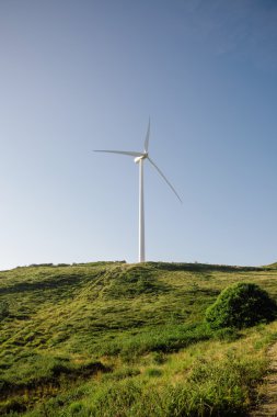 Mavi gökyüzü arka plan üzerinde elektrik üreten rüzgar türbini 