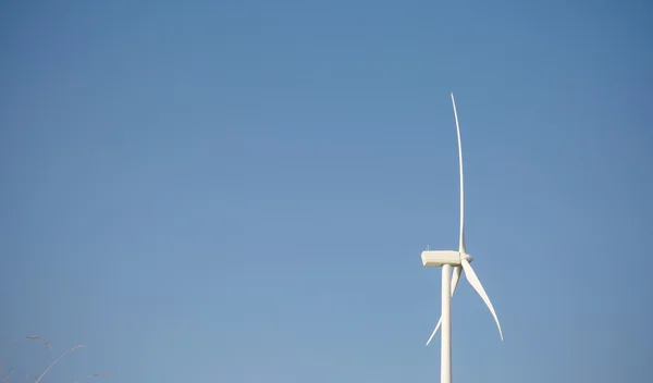 Vindkraftverk genererar elektricitet över blå himmel bakgrund — Stockfoto