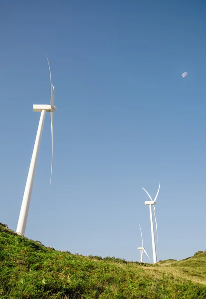 Wind turbines generating electricity over blue sky background — Stock Photo, Image