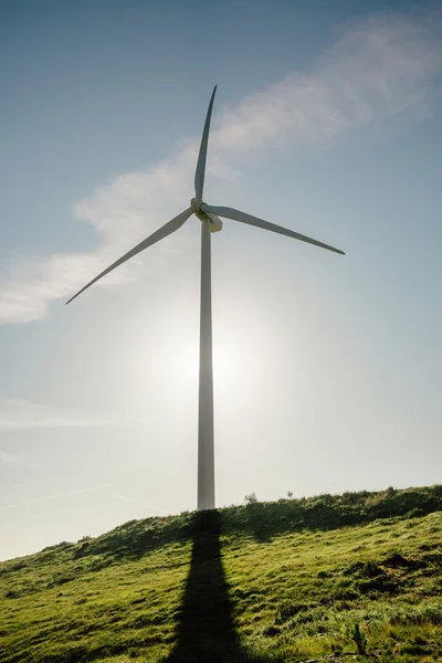 Turbinę wytwarzającą energię elektryczną na tle błękitnego nieba — Zdjęcie stockowe