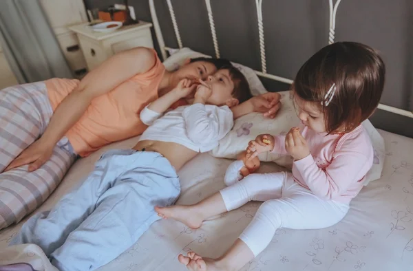 Avslappnad barn äta kakor över sängen — Stockfoto