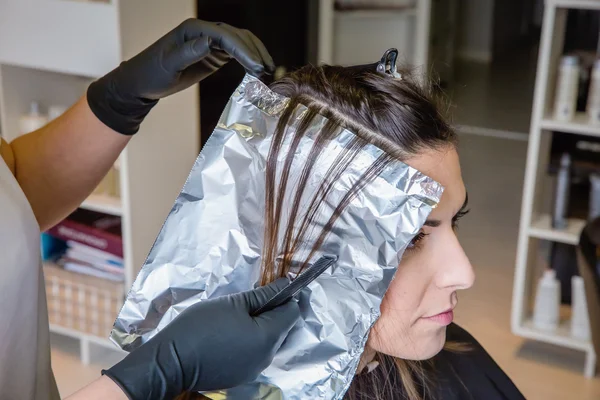 Tangan penata rambut memisahkan rambut wanita dengan kertas aluminium — Stok Foto