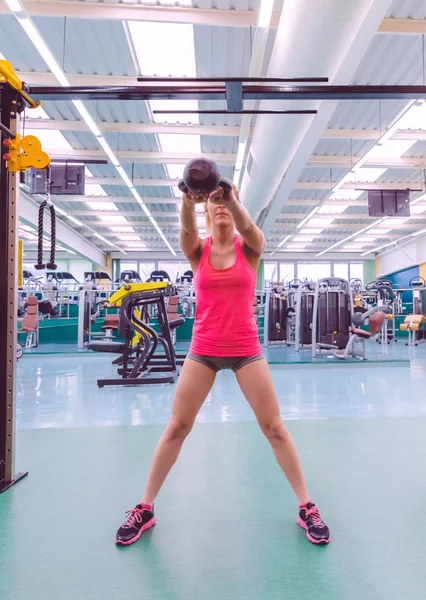 Mulher levantando kettlebell no treinamento crossfit — Fotografia de Stock