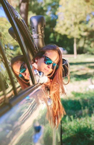 Jovem mulher olhando para trás através do carro da janela — Fotografia de Stock