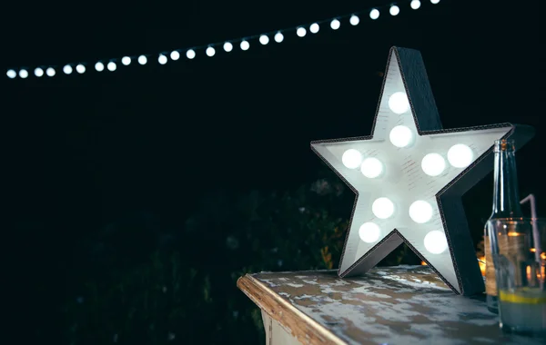Lampă stelară albă cu becuri peste masa de lemn — Fotografie, imagine de stoc