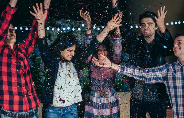 Щасливі друзі розважаються серед партії confetti — стокове фото