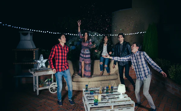 Amigos felizes se divertindo entre o confetti festa — Fotografia de Stock