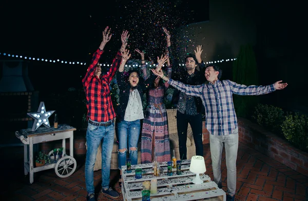 Amigos felizes se divertindo entre o confetti festa — Fotografia de Stock