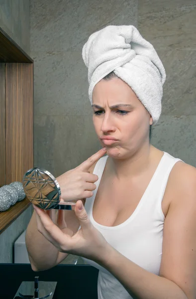 Mulher infeliz olhando uma espinha de acne no espelho — Fotografia de Stock