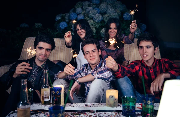 Amigos felizes segurando sparklers em uma festa — Fotografia de Stock