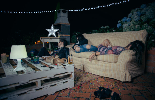 Молодые пьяные друзья спят на диване после вечеринки
