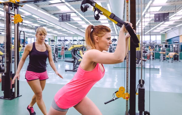 Personal trainer helping to woman in suspension training — Stock Photo, Image